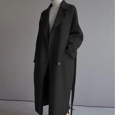 Modell steht mit schwarzen langem Wollmantel vorne.